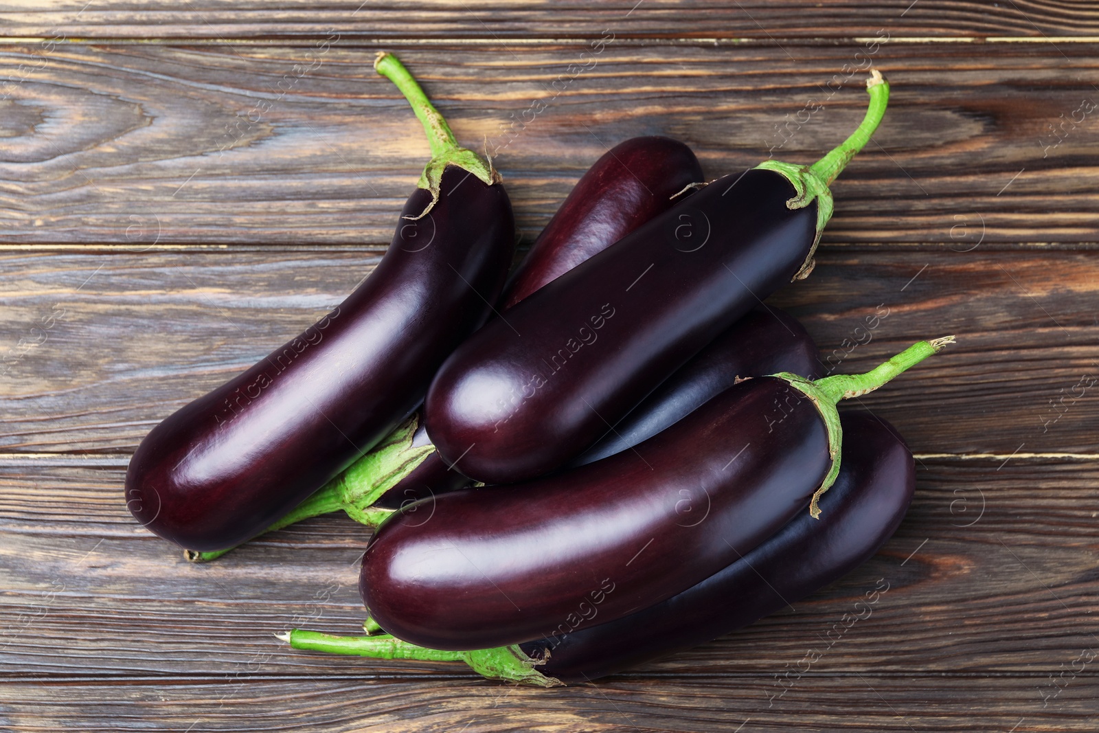 Photo of Many ripe eggplants on wooden table, top view