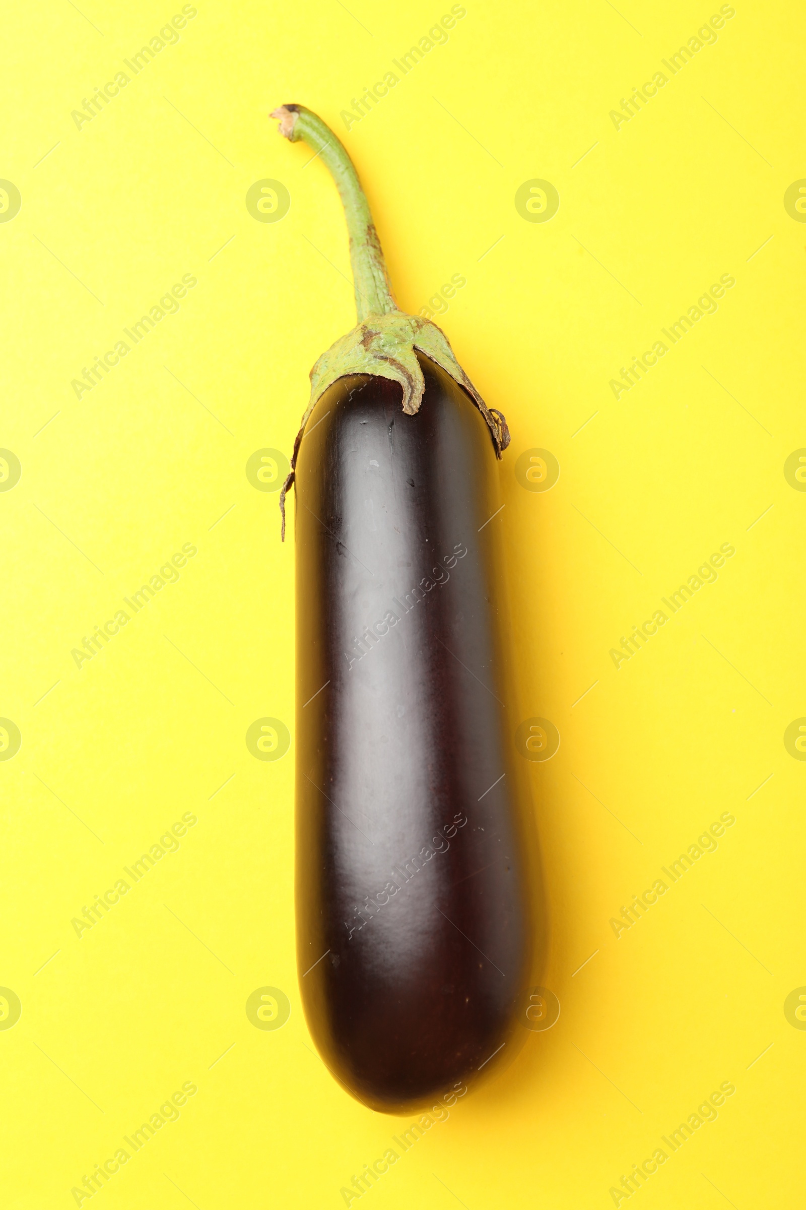 Photo of Ripe eggplant on yellow background, top view