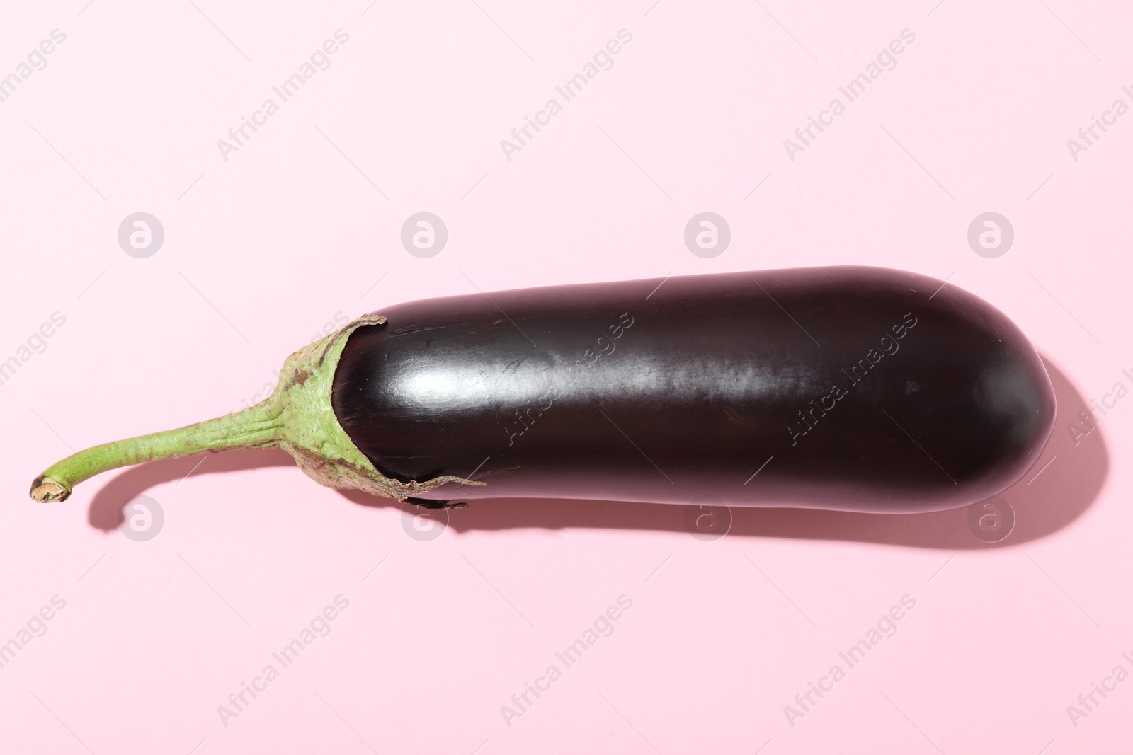 Ripe eggplant on light pink background, top view Photo of Ripe eggplant on light pink background, top view