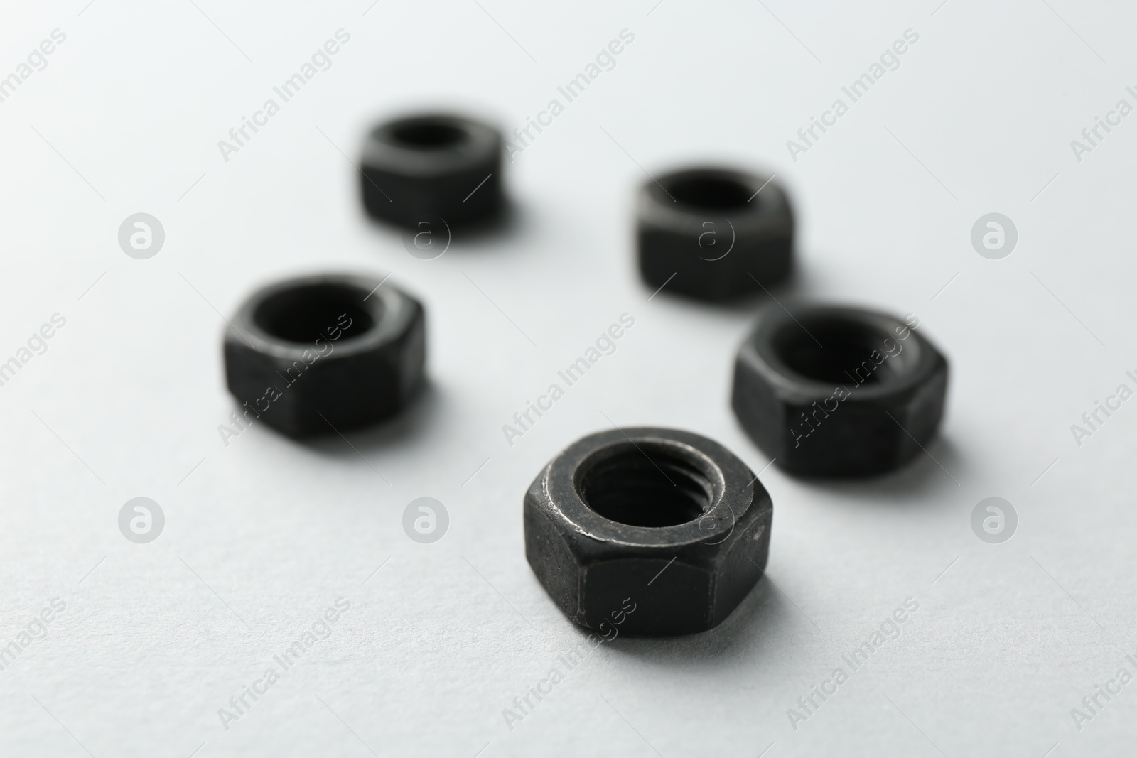 Metal hex nuts on white background, closeup Photo of Metal hex nuts on white background, closeup