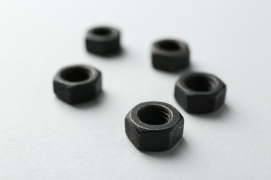 Photo of Metal hex nuts on white background, closeup