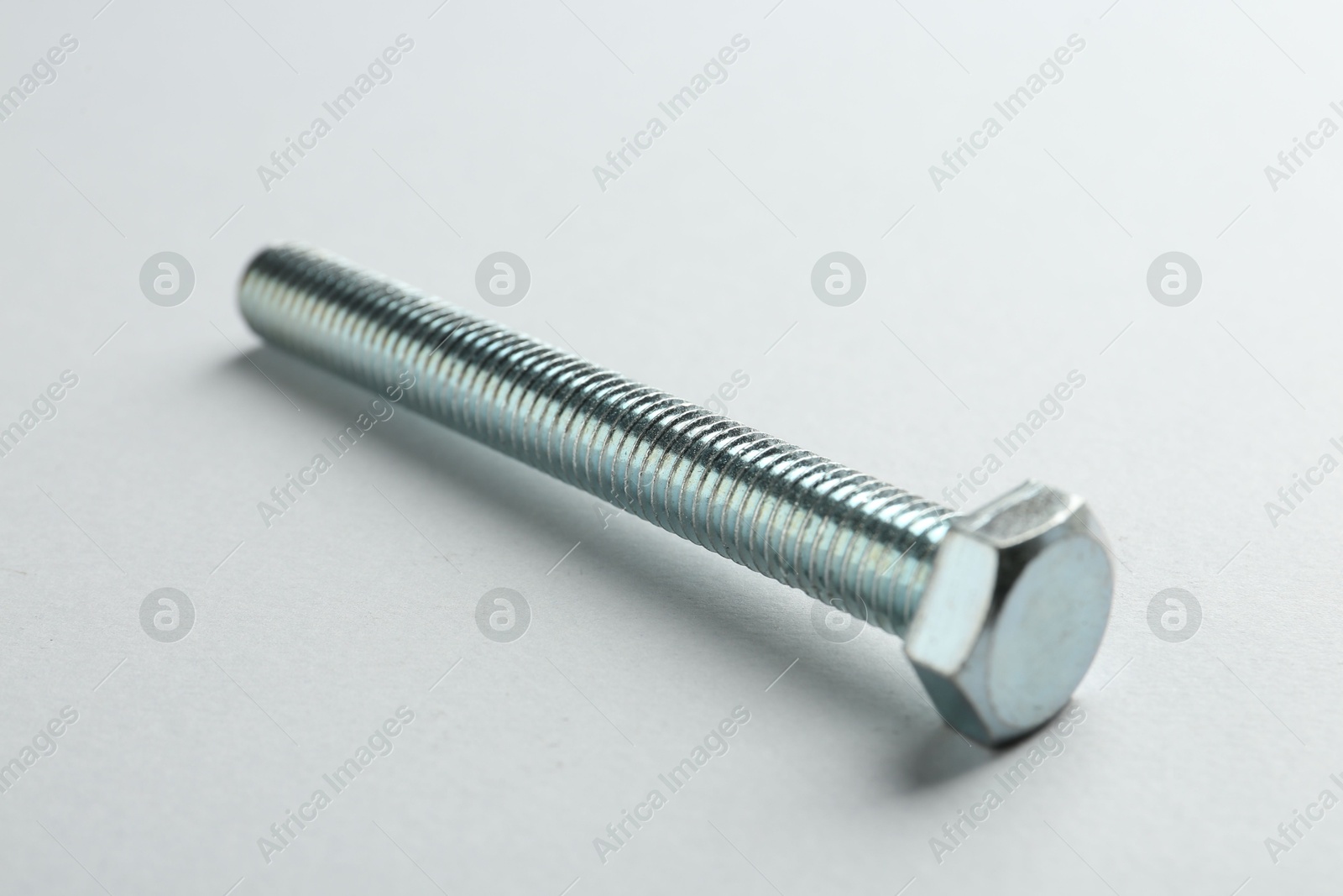One metal bolt on white background, closeup. Hardware tool Photo of One metal bolt on white background, closeup. Hardware tool