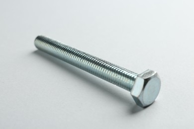 Photo of One metal bolt on white background, closeup. Hardware tool