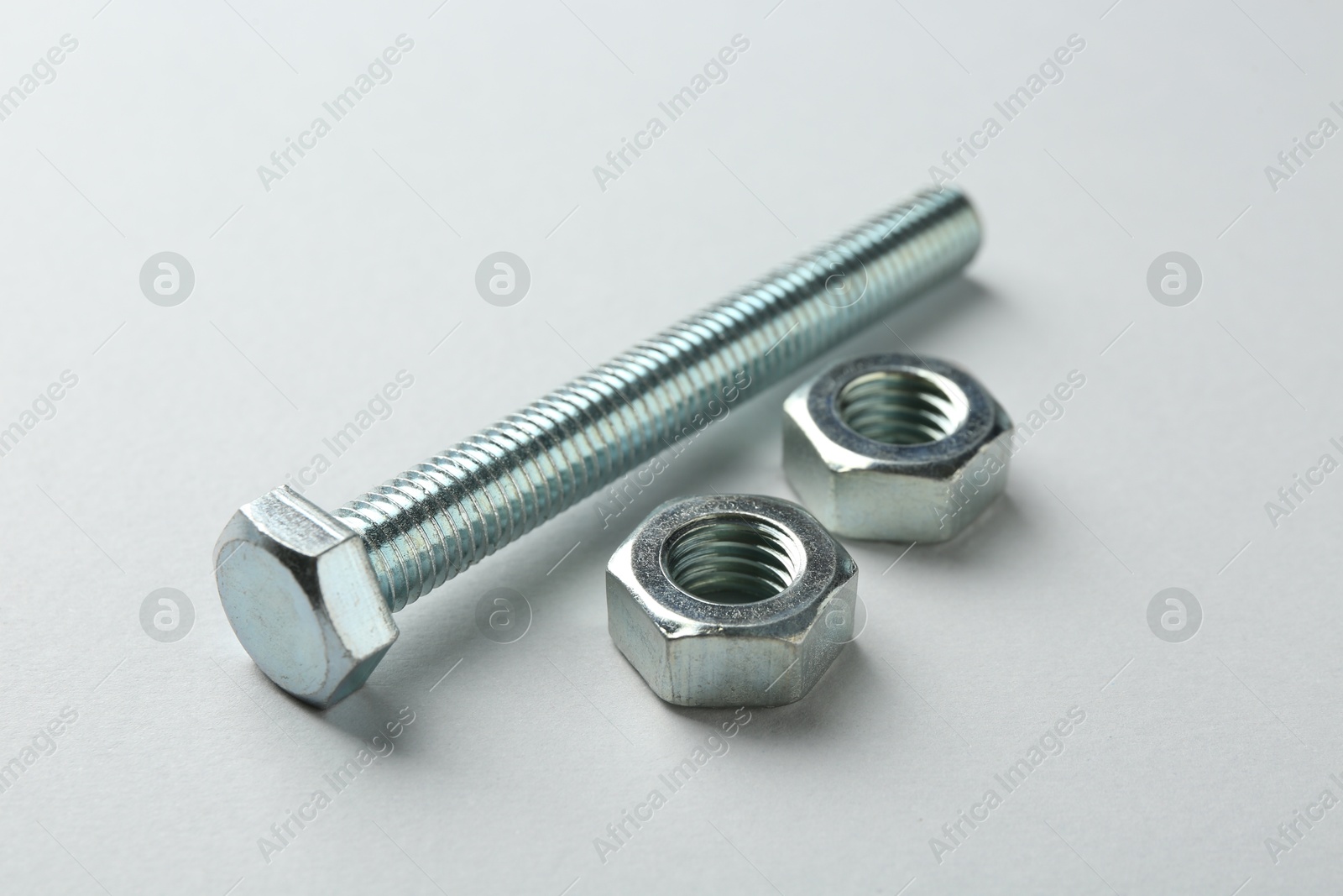 Metal bolt and nuts on white background, closeup. Hardware tool Photo of Metal bolt and nuts on white background, closeup. Hardware tool