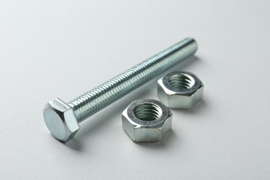 Photo of Metal bolt and nuts on white background, closeup. Hardware tool