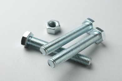 Photo of Metal bolts and nut on white background, closeup. Hardware tool