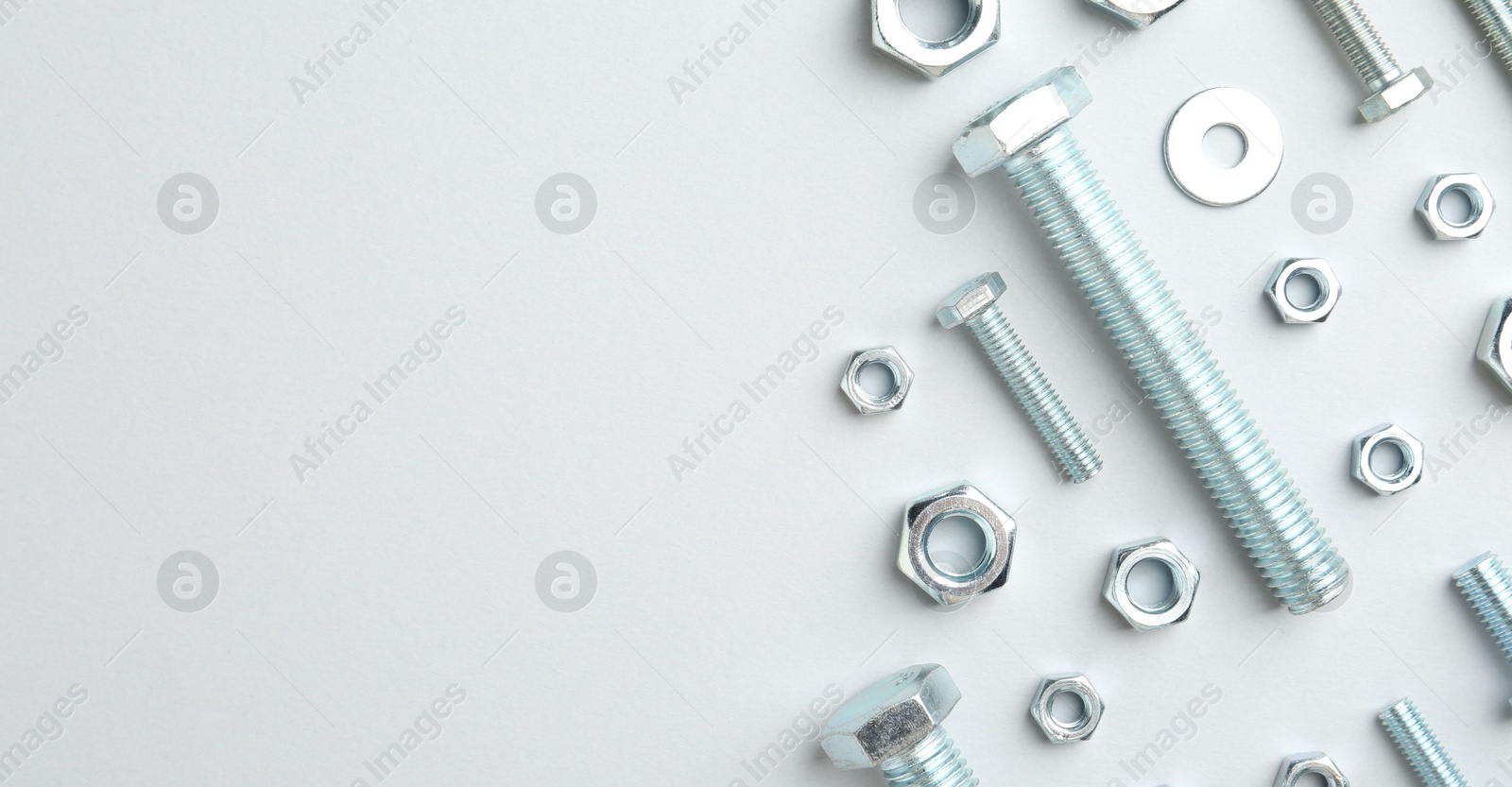 Metal bolts and nuts on white background, flat lay. Space for text Photo of Metal bolts and nuts on white background, flat lay. Space for text