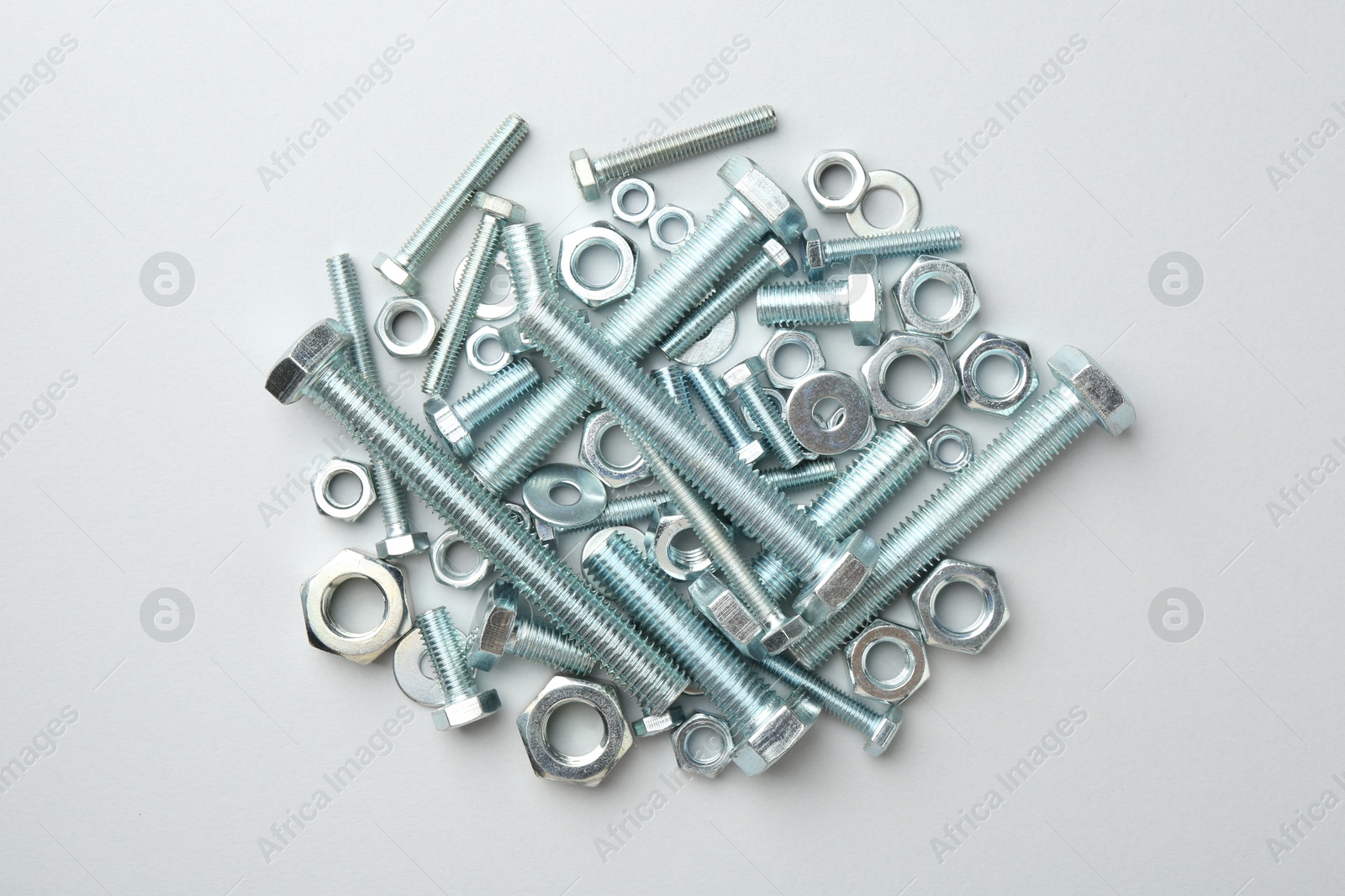 Metal bolts and nuts on white background, flat lay Photo of Metal bolts and nuts on white background, flat lay