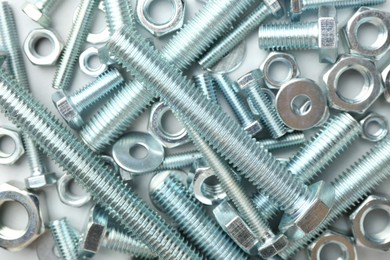 Photo of Metal bolts and nuts on white background, flat lay