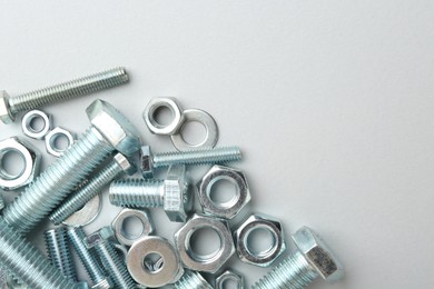 Photo of Metal bolts and nuts on white background, flat lay. Space for text