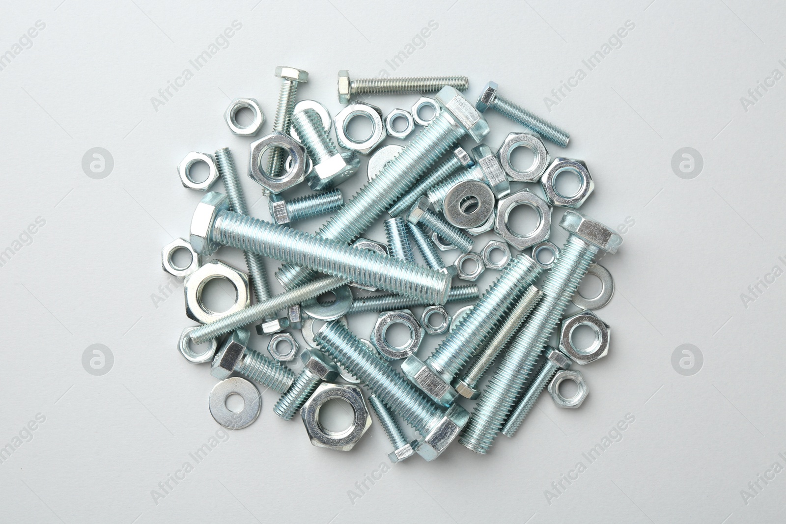 Metal bolts and nuts on white background, flat lay Photo of Metal bolts and nuts on white background, flat lay