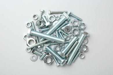 Photo of Metal bolts and nuts on white background, flat lay