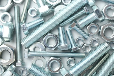 Photo of Metal bolts and nuts on white background, flat lay