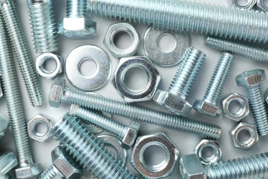 Photo of Metal bolts and nuts on white background, flat lay