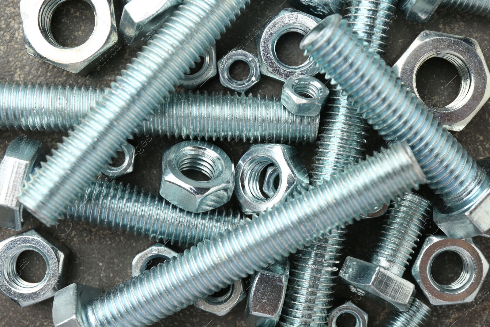 Metal bolts and nuts on grey table, flat lay Photo of Metal bolts and nuts on grey table, flat lay