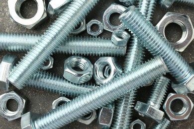 Photo of Metal bolts and nuts on grey table, flat lay