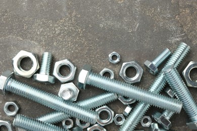 Photo of Metal bolts and nuts on grey table, flat lay. Space for text