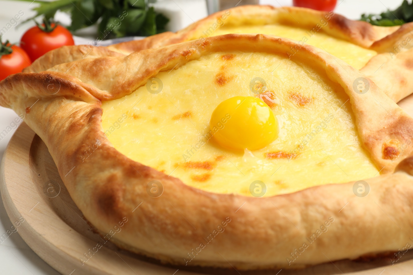 Tasty khachapuris with cheese and egg on table, closeup Photo of Tasty khachapuris with cheese and egg on table, closeup
