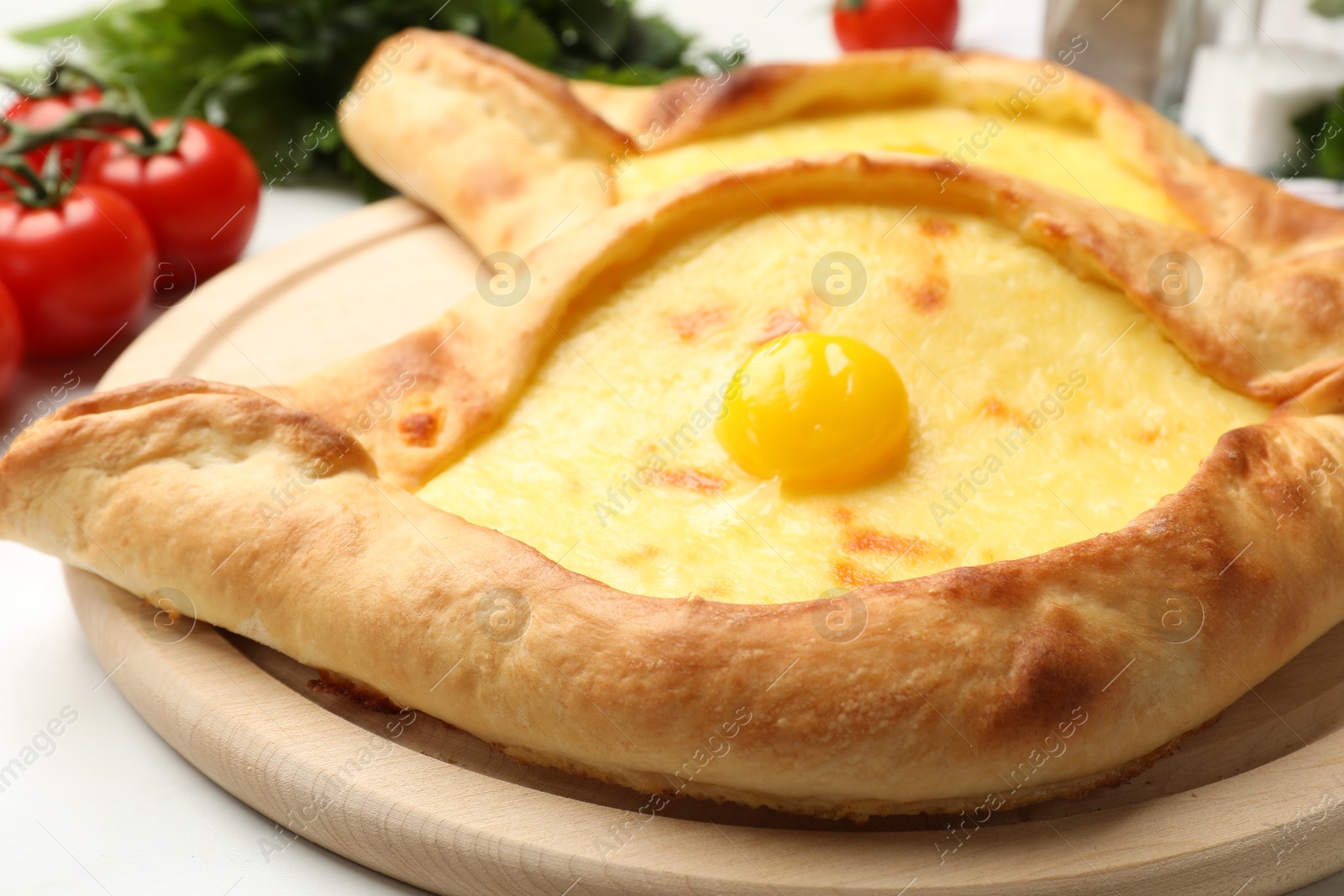 Tasty khachapuris with cheese and egg on white table, closeup Photo of Tasty khachapuris with cheese and egg on white table, closeup