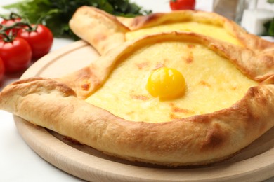 Photo of Tasty khachapuris with cheese and egg on white table, closeup