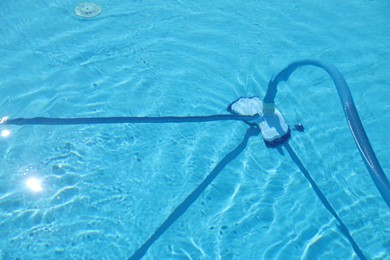 Photo of Cleaning outdoor pool with underwater vacuum, closeup