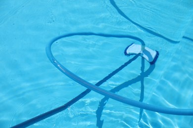 Photo of Cleaning outdoor pool with underwater vacuum, closeup