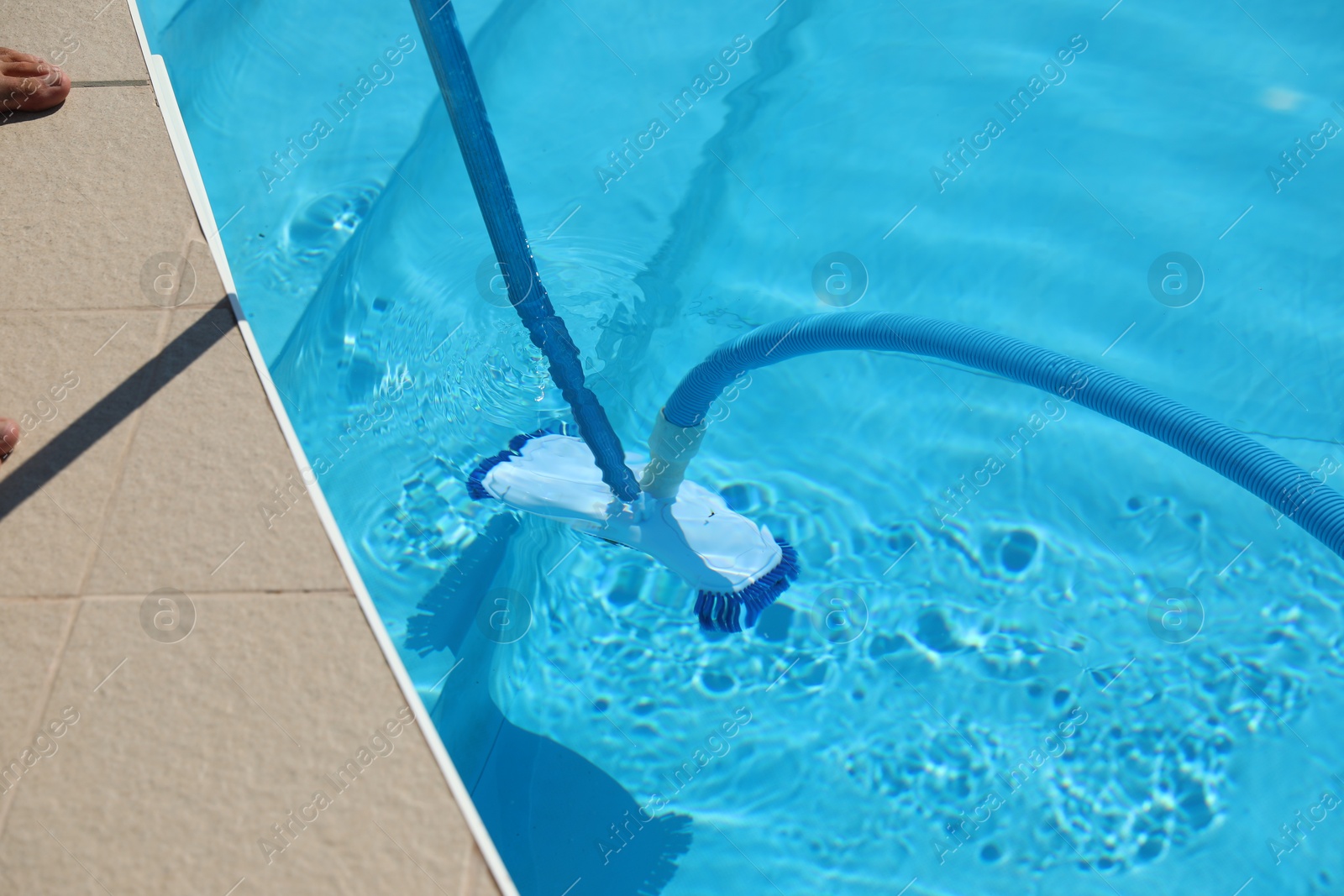 Cleaning outdoor pool with underwater vacuum, closeup Photo of Cleaning outdoor pool with underwater vacuum, closeup