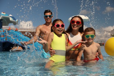 Photo of Happy family having fun at water park. Summer vacation