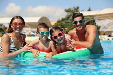 Photo of Happy family in swimming pool. Summer vacation