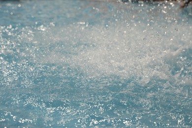 Photo of Splashes in swimming pool on sunny day. Summer vacation