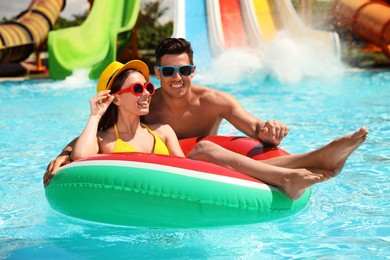 Photo of Happy couple with inflatable ring at water park. Summer vacation