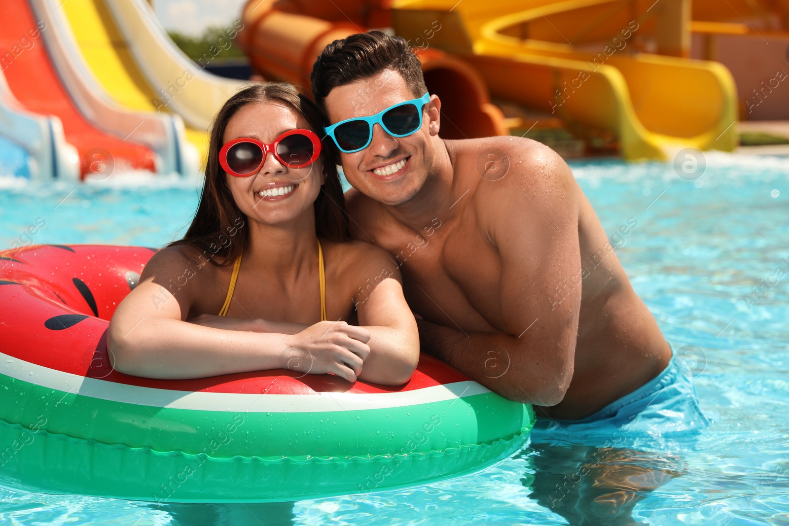Happy couple with inflatable ring at water park. Summer vacation Photo of Happy couple with inflatable ring at water park. Summer vacation