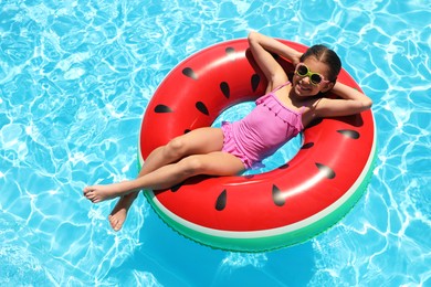 Photo of Girl on inflatable ring in swimming pool. summer vacation