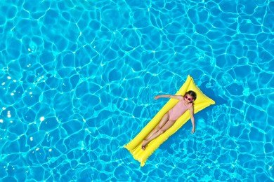 Photo of Girl on inflatable mattress in swimming pool, top view. Summer vacation