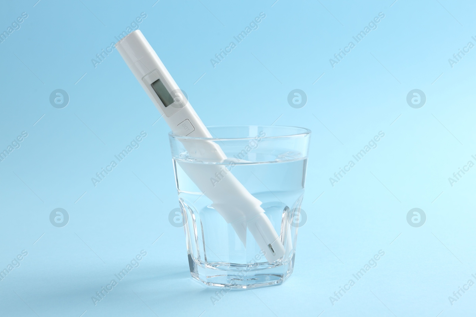 Nitrate tester in glass of water on light blue background Photo of Nitrate tester in glass of water on light blue background