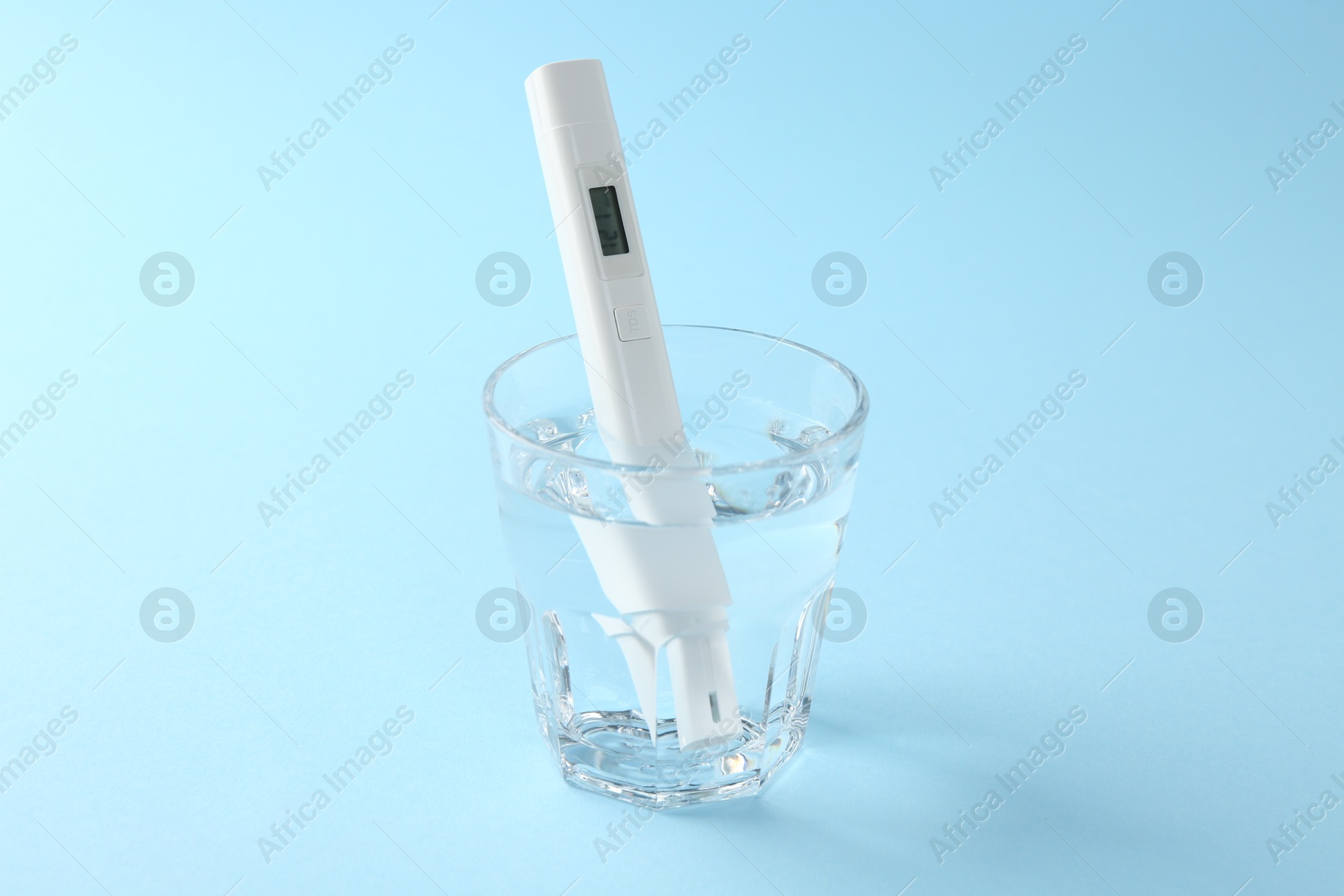 Nitrate tester in glass of water on light blue background, closeup Photo of Nitrate tester in glass of water on light blue background, closeup