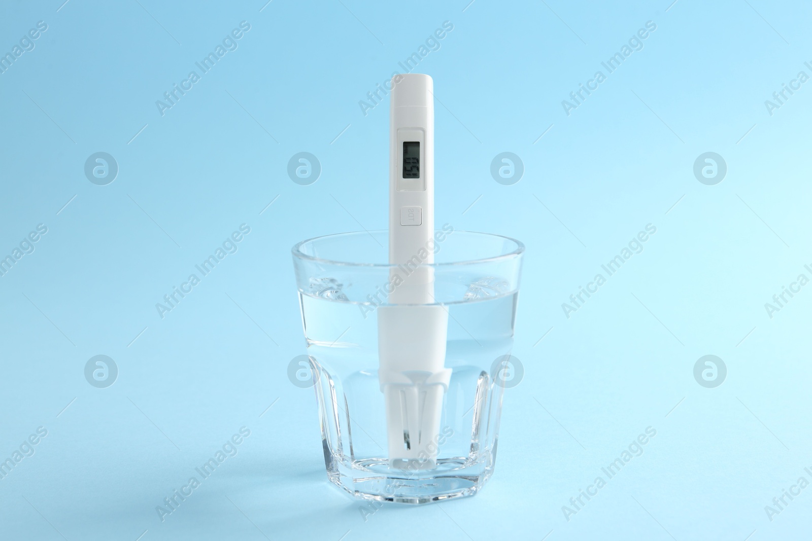 Nitrate tester in glass of water on light blue background, closeup Photo of Nitrate tester in glass of water on light blue background, closeup