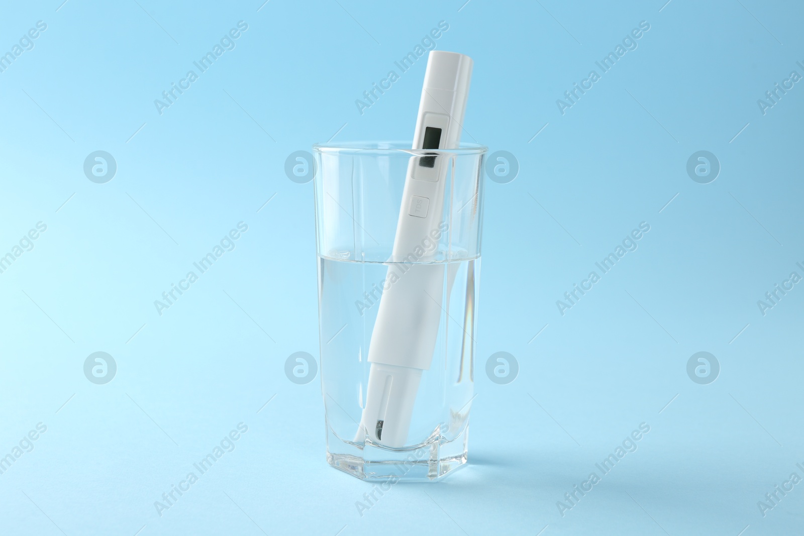 Nitrate tester in glass of water on light blue background Photo of Nitrate tester in glass of water on light blue background