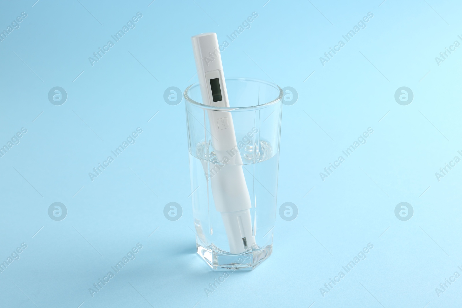 Nitrate tester in glass of water on light blue background Photo of Nitrate tester in glass of water on light blue background