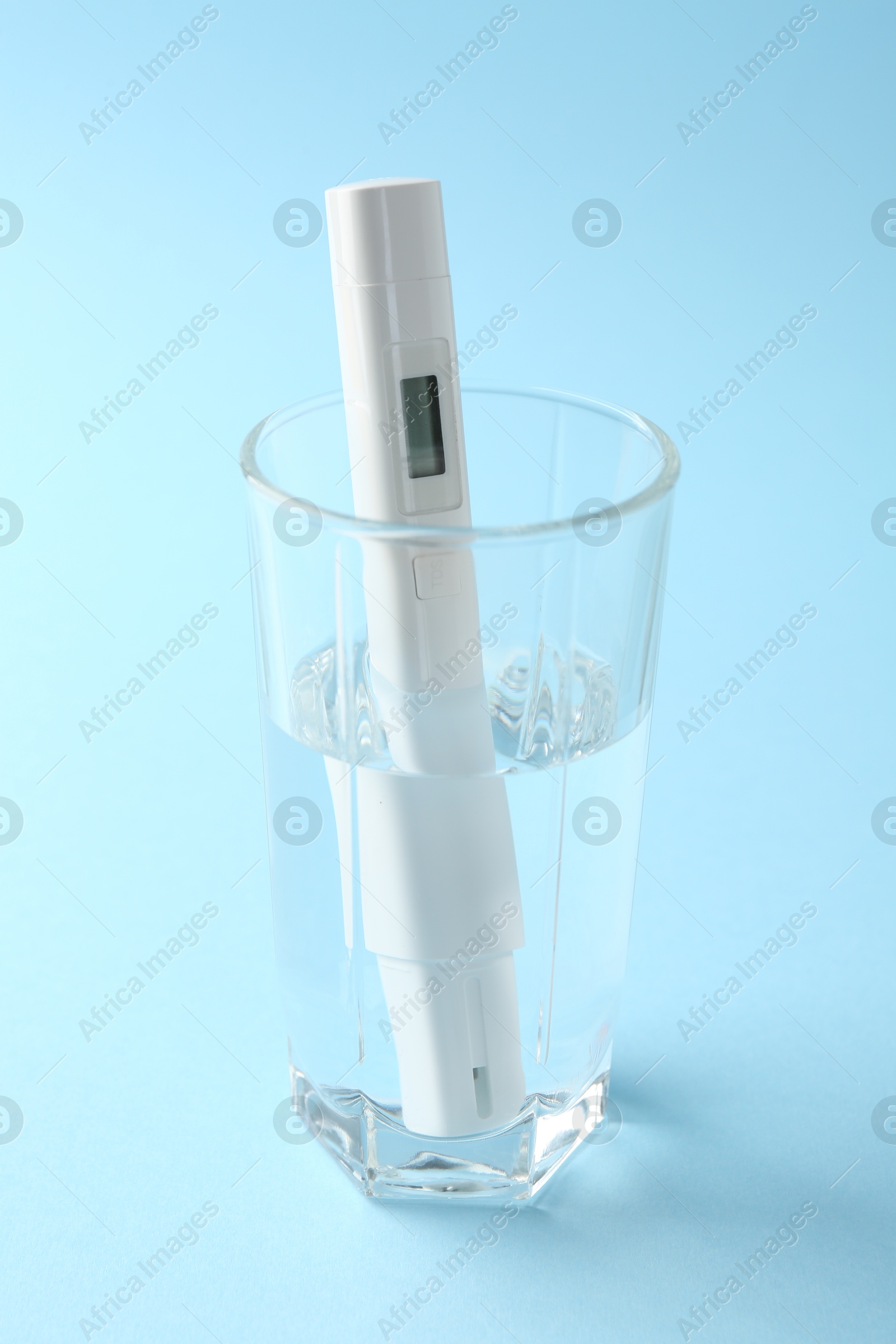 Nitrate tester in glass of water on light blue background, closeup Photo of Nitrate tester in glass of water on light blue background, closeup