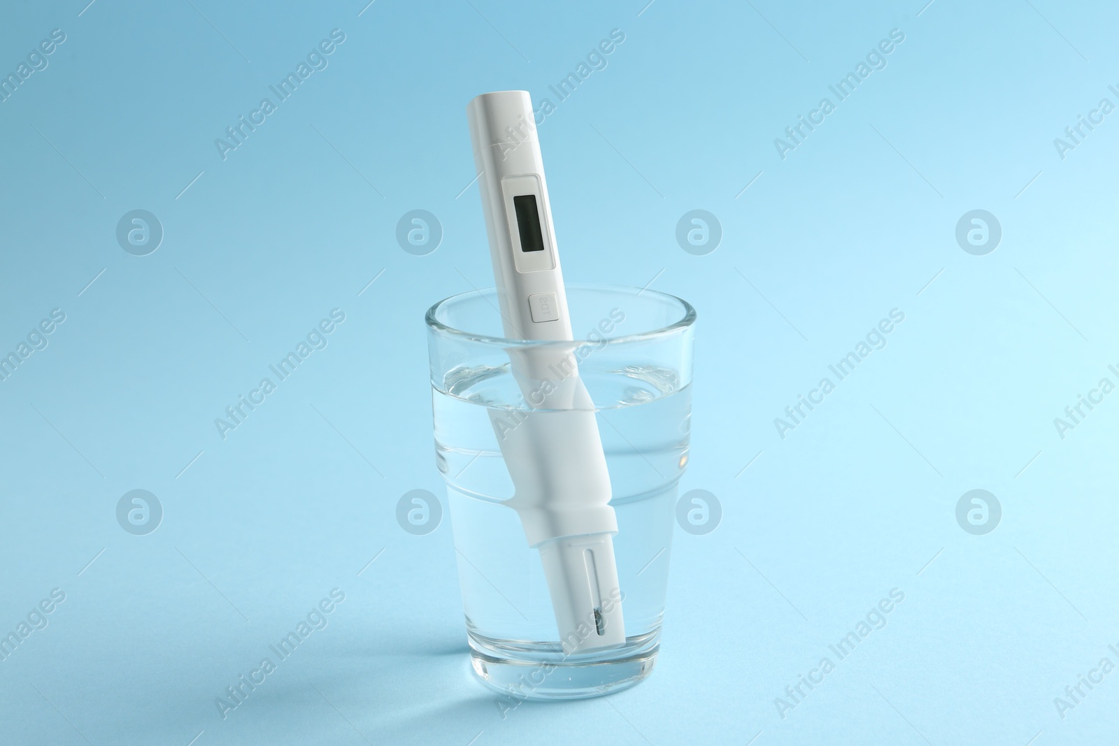 Nitrate tester in glass of water on light blue background Photo of Nitrate tester in glass of water on light blue background