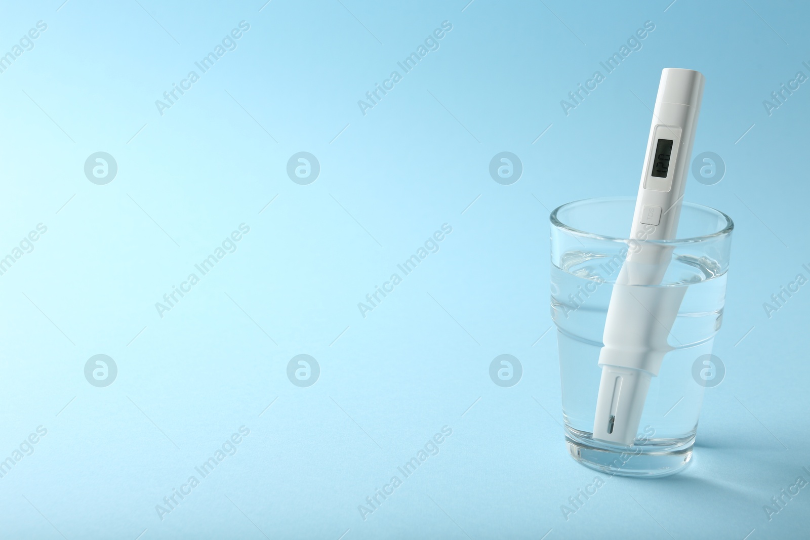 Nitrate tester in glass of water on light blue background, space for text Photo of Nitrate tester in glass of water on light blue background, space for text