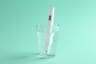 Photo of Nitrate tester in glass of water on turquoise background