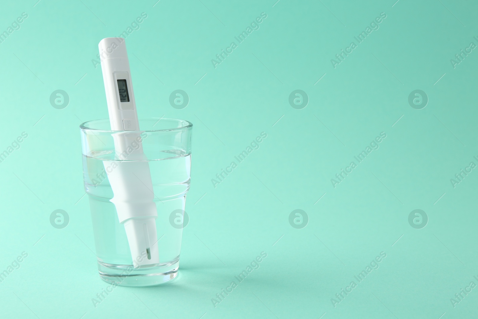 Nitrate tester in glass of water on turquoise background, space for text Photo of Nitrate tester in glass of water on turquoise background, space for text