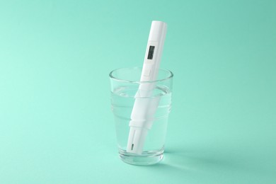Photo of Nitrate tester in glass of water on turquoise background