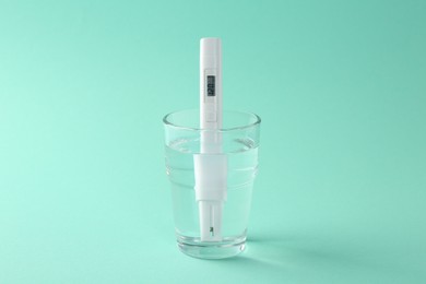 Photo of Nitrate tester in glass of water on turquoise background