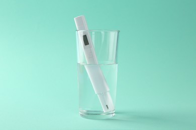 Photo of Nitrate tester in glass of water on turquoise background