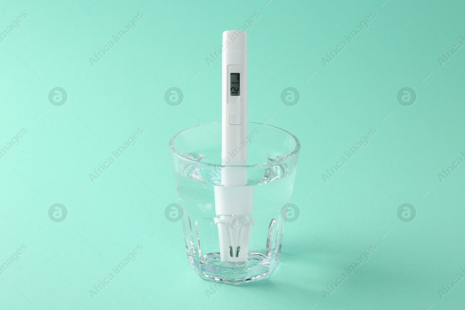 Nitrate tester in glass of water on turquoise background, closeup Photo of Nitrate tester in glass of water on turquoise background, closeup