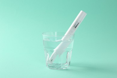 Photo of Nitrate tester in glass of water on turquoise background