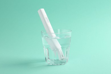 Photo of Nitrate tester in glass of water on turquoise background